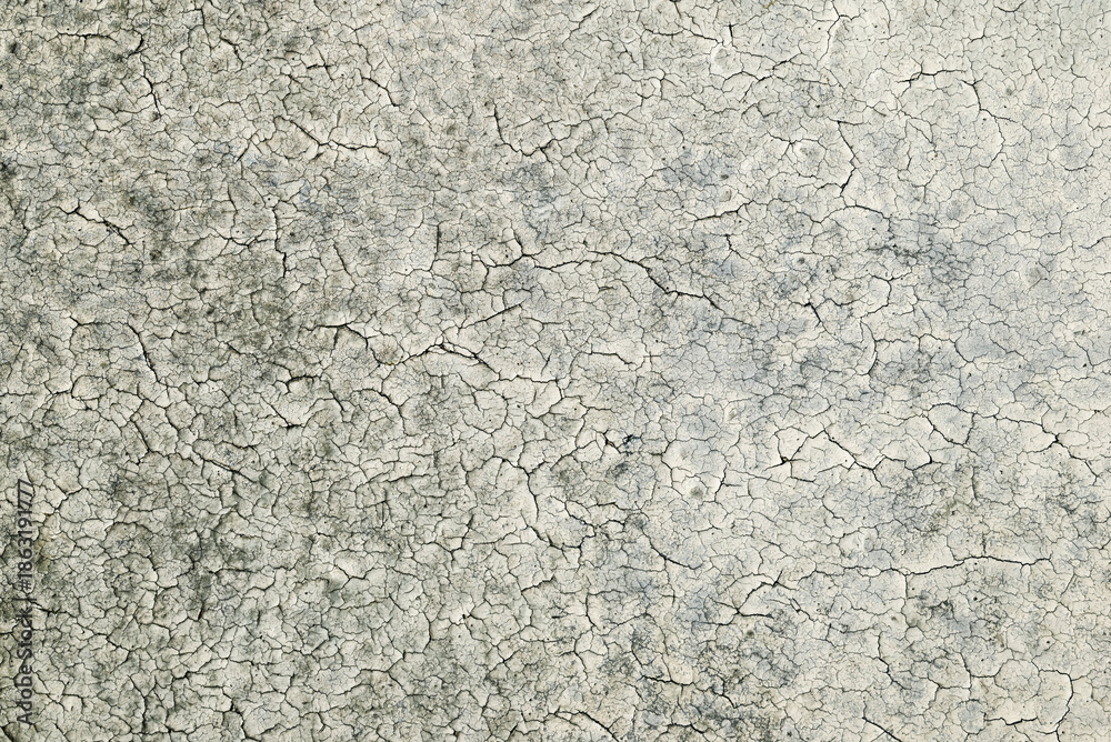 Obraz premium Close-up of deteriorated plaster surface with cracked paint layer. Distressed wall texture suitable for backgrounds, overlays, and creative design use.