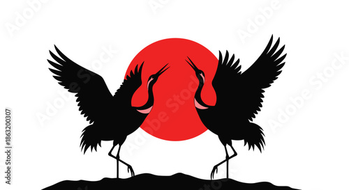 A beautiful silhouette of two Japanese red-crowned cranes performing a courtship dance against a large red sun.