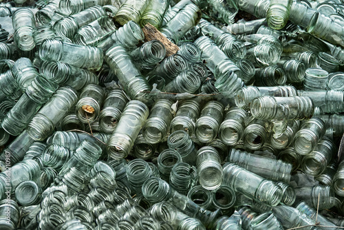 Empty glass sauce jars (industrial glass container) piled high, production has stopped, production slump, non returned empties concept. Jars background