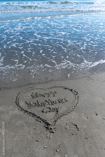 A heart is drawn in the sand on a beach