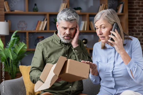 Obraz na plátne Mature couple feeling shocked and disappointed, discovering an empty delivery pa