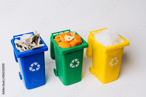 Three color-coded recycle bins filled with various materials, showcasing the importance of recycling and environmental sustainability practices