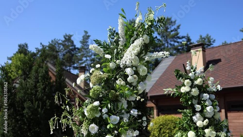 White floral decorative arch outside on a wedding