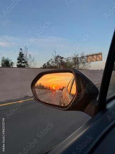 Sunset Reflected in Car Side Mirror on Open Highway