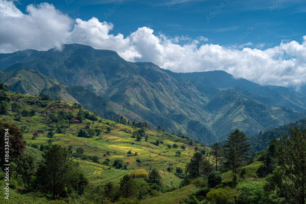 Fototapeta premium The lush, vibrant landscapes of the Ixil Triangle, with abstract cloud-kissed mountains and terraced agricultural plots.