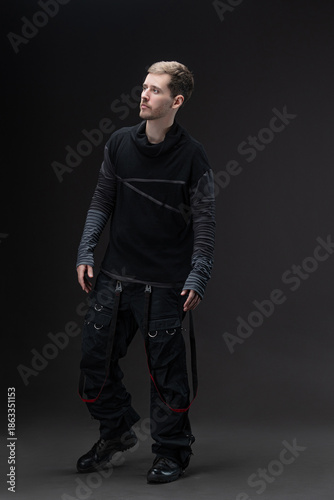 Φωτογραφία Street style: young man in baggy cyberpunk fashion posing on studio gray
