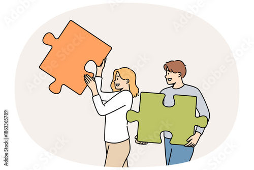 Couple of man and woman are working on building relationships, holding puzzle pieces in hands. Operating together on relationships to create strong family and avoid quarrels and disagreements
