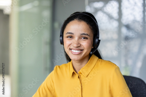 Canvastavla Friendly mixed race woman wearing a headset and yellow shirt, providing excellen