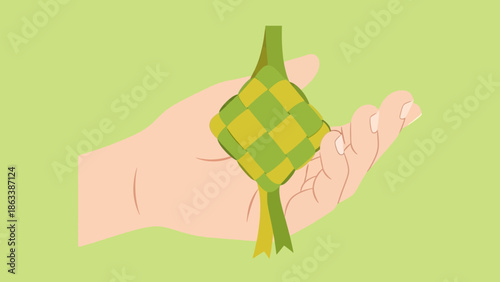 Hand holding a traditional Ketupat a symbol of Eid al-Fitr celebration.