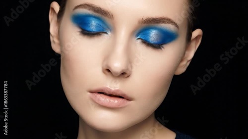 Stunning Woman with Bold Blue Eyeshadow and Flawless Skin.