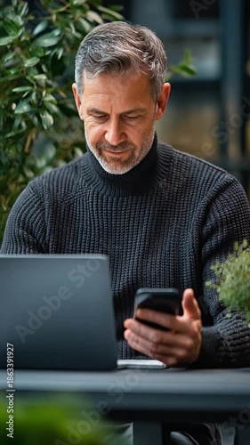 Man Using Laptop and Mobile Phone Outdoors.