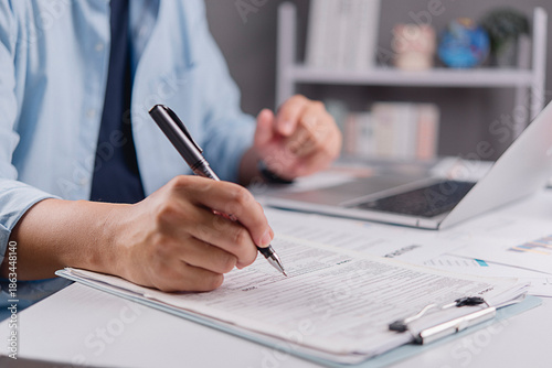 Tableau sur toile Businessman hand filling out tax return form or insurance application document
