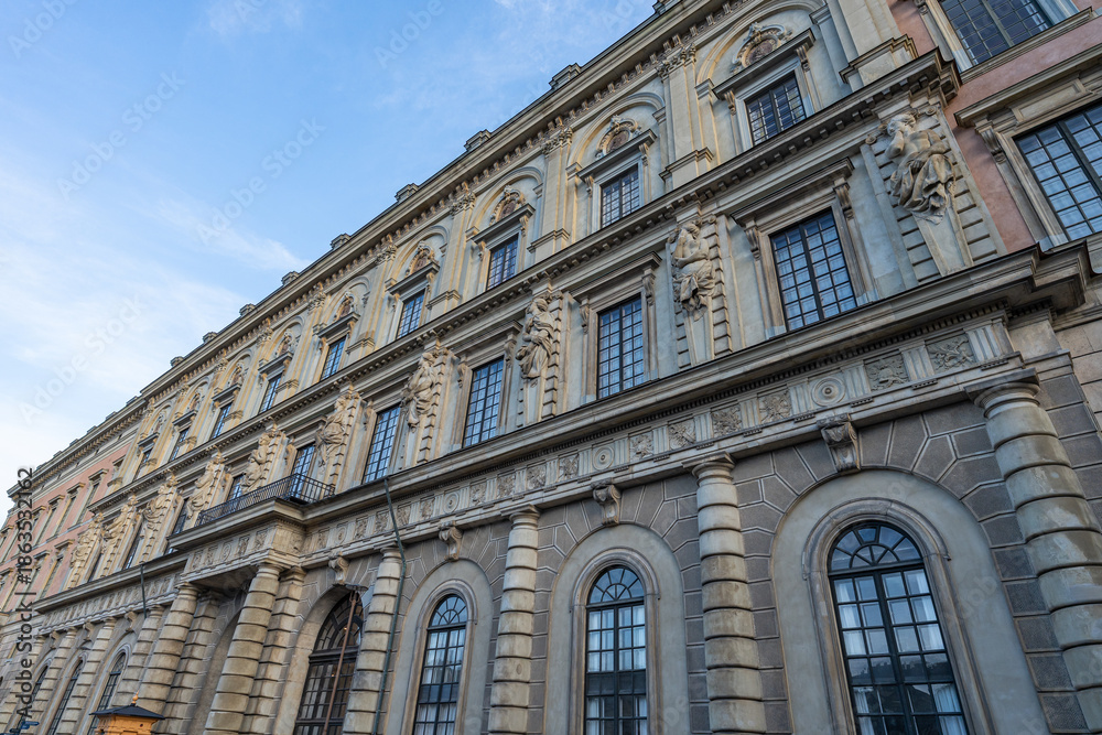 Obraz premium Ornate exterior facade of the Royal Palace in Stockholm, Sweden, highlighting baroque architectural elements, sculpted stone figures, arched windows, decorative columns, and historic European design u