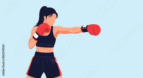 Athletic young woman wearing red boxing gloves practices a strong punch during her intense workout session in a gym.
