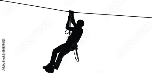 Silhouette of a man sliding on a zipline cable, concept for extreme sports, adventure, outdoor activity, risk, and adrenaline rush