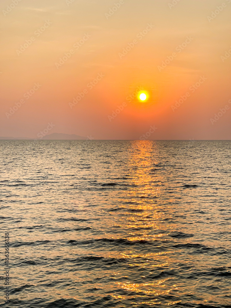 Obraz premium Sea surface with sunlight sparkle. A beautiful sunset sunrise in the sea, silhouette style.