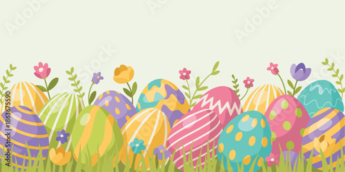 A delightful collection of vividly patterned Easter eggs nestled in fresh green grass with small spring flowers