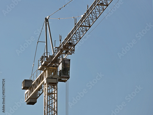Tower cranes work during the construction of a multi-story building. New apartments for residents and premises for offices. Risky work at height. Lifting heavy building materials. City development