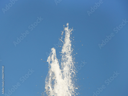 A stob of water striking up against a blue sky. Spray fountain in the sun. Delivery of drinking water to the city for the population. Irrigation of arid soil. Pure drinking water to quench your thirst