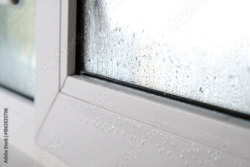 Drops of condensation on PVC windows in a house, close-up.