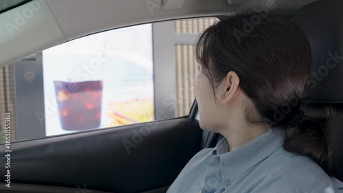 Asian young woman order or pay for food or drinks and paid by credit card by driving through or drive thru. Contactless payment, Contactless Delivery.
