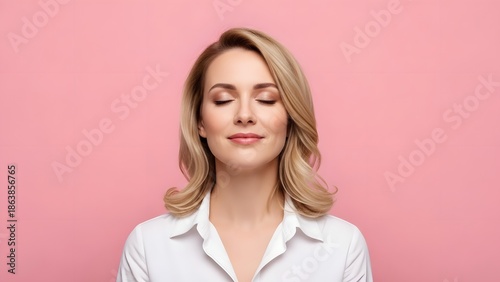 A serene blonde woman with closed eyes and a gentle smile against a pink background.