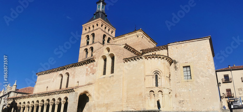 Historic Romanesque stone church with blue sky background in Segovia city