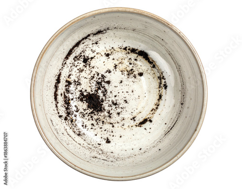 Overhead view of a ceramic bowl with remnants of dark-colored crumbs