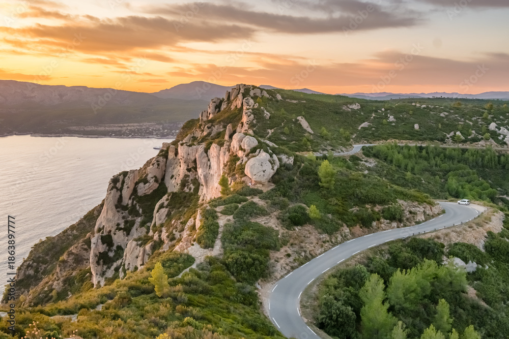 Obraz premium Aerial view of the picturesque Route de Crete road between Cassis and La Ciotat during sunset, southern France.