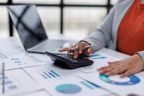 Business woman analysis summary graph reports of business operating expenses and work data about the company's financial statements.
