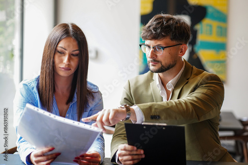 Tableau sur toile Business meeting between two professionals discussing project details in a moder