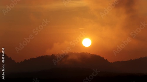 Time-lapse of sunrise glowing behind mountains