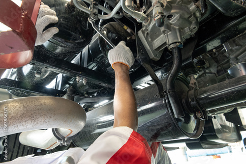 Canvastavla Mechanic hands inspecting and repairing the chassis and undercarriage of a heavy truck 
Close-up of a professional technician in uniform working under a vehicle