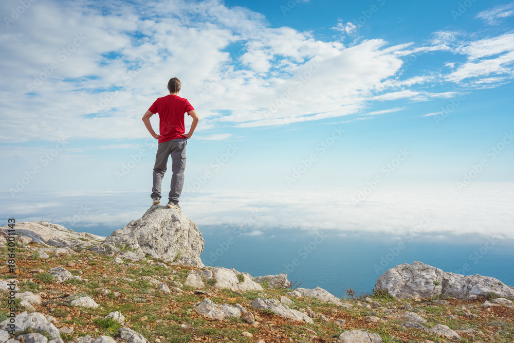 Obraz premium Man on sea cliff edge and blue sky at spring day.