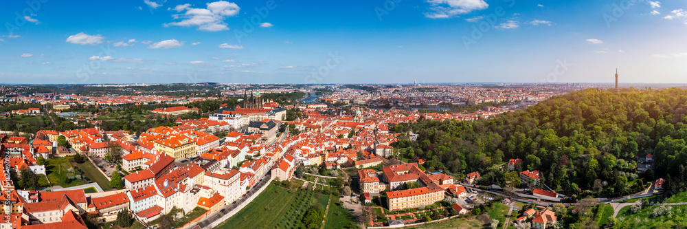 Fototapeta premium Panoramic view of Prague featuring historic buildings and vibrant rooftops on a sunny day in summer. View of Prague, Czech Republic, showcasing Prague iconic architecture and red-tiled roofs, Czechia
