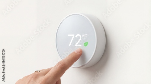 Hand adjusting smart thermostat to 72 degrees Fahrenheit