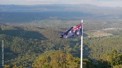 Scenic elevated views of the Australia flag on display at the Picnic Point public park area in Toowoomba with Table Top Mountain and the Bushland Reserve in the background, Queensland, Australia