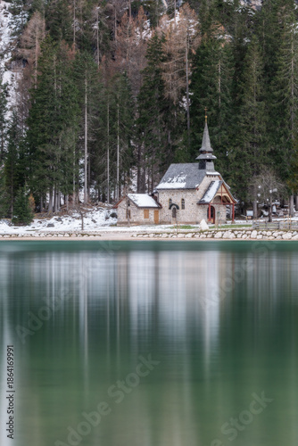 Pragser wildsee chapel reflecting in lake braies with snow