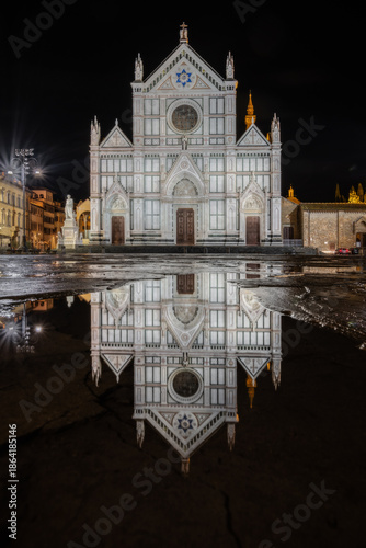 Basilica of santa croce reflecting in puddle at night