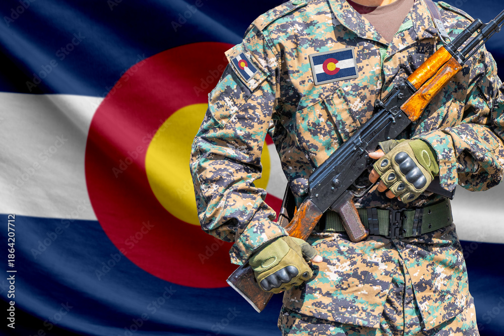 Fototapeta premium Colorado US state flag with soldier holding assault rifle in front of it