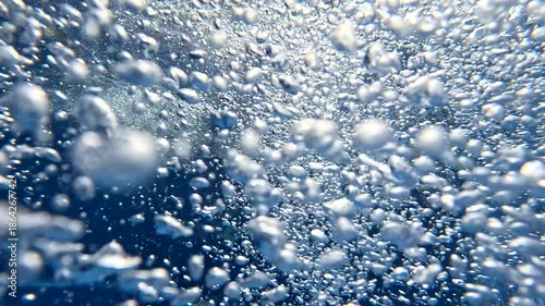 Bubbles rising in underwater environment during daytime hours