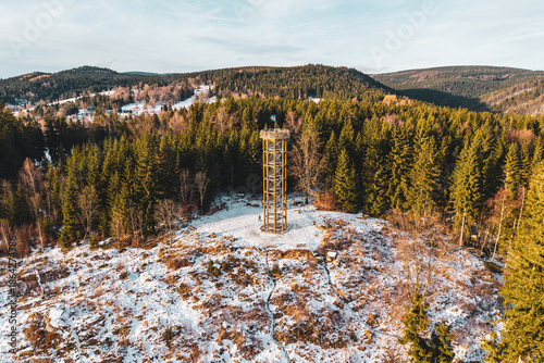 Svetly vrch lookout tower stands tall in Albrechtice. Surrounded by snow and trees, it offers a view of the Jizera mountains. People can explore nature and enjoy the winter scene.