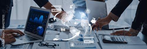 Tableau sur toile Team of diverse professionals analyzing data on laptops in a modern office setting, showcasing a digital connection to global business and innovation strategies