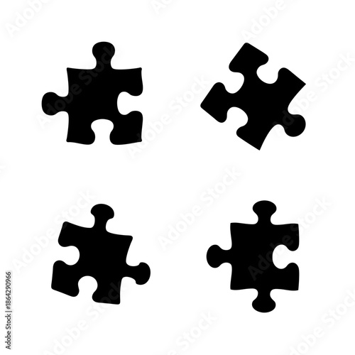 Four distinct black puzzle pieces scattered across a clean white background, symbolizing problem-solving and connection