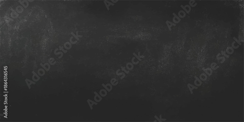 An empty vintage black chalkboard with a grunge textured surface set against a dark aged stone wall backdrop