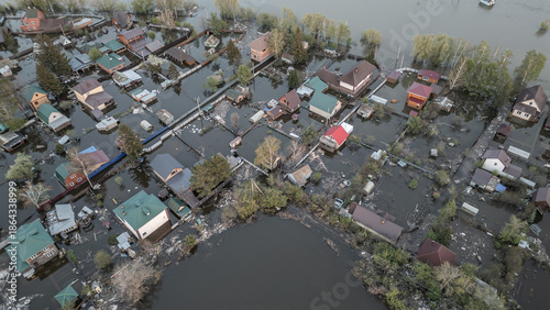 Aerial drone footage of a massive city flood with houses and streets submerged under water. Urban flooding caused by extreme weather and heavy rainfall, showing natural disaster impact on residential 