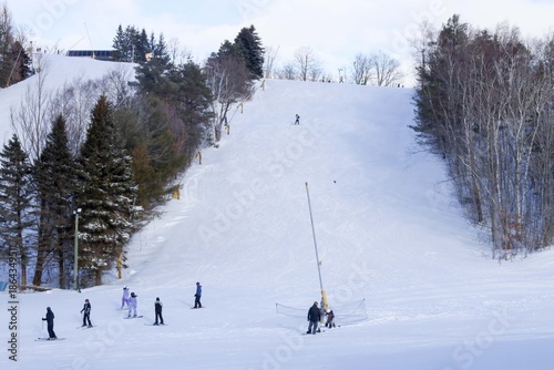 
A sweeping winter landscape stretches across the frame, showcasing a lively Ontario ski resort nestled among snow‑covered evergreens. 