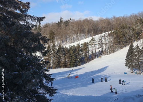 
A sweeping winter landscape stretches across the frame, showcasing a lively Ontario ski resort nestled among snow‑covered evergreens. 