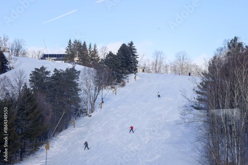 
A sweeping winter landscape stretches across the frame, showcasing a lively Ontario ski resort nestled among snow‑covered evergreens. 