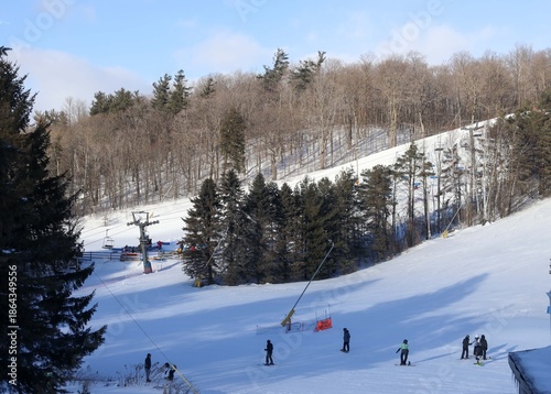 
A sweeping winter landscape stretches across the frame, showcasing a lively Ontario ski resort nestled among snow‑covered evergreens. 